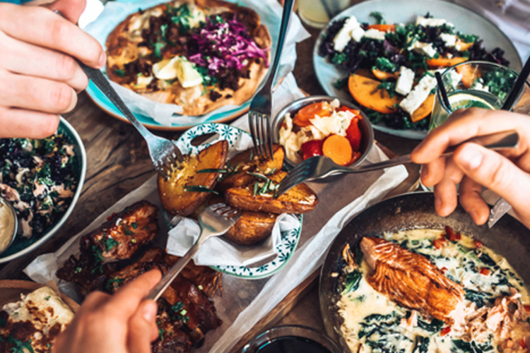 overhead view of family dining out sharing multiple dishes