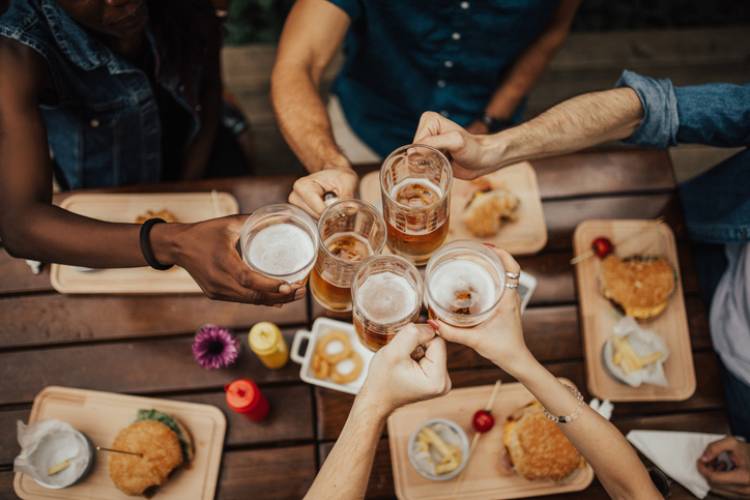 Friends cheer over beers and burgers