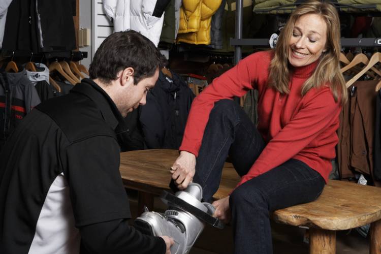 A woman trying on a ski boot